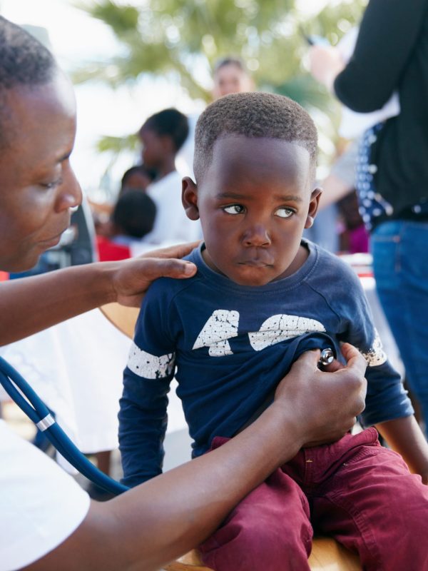 Shot of a volunteer doctor giving checkups to underprivileged kids.